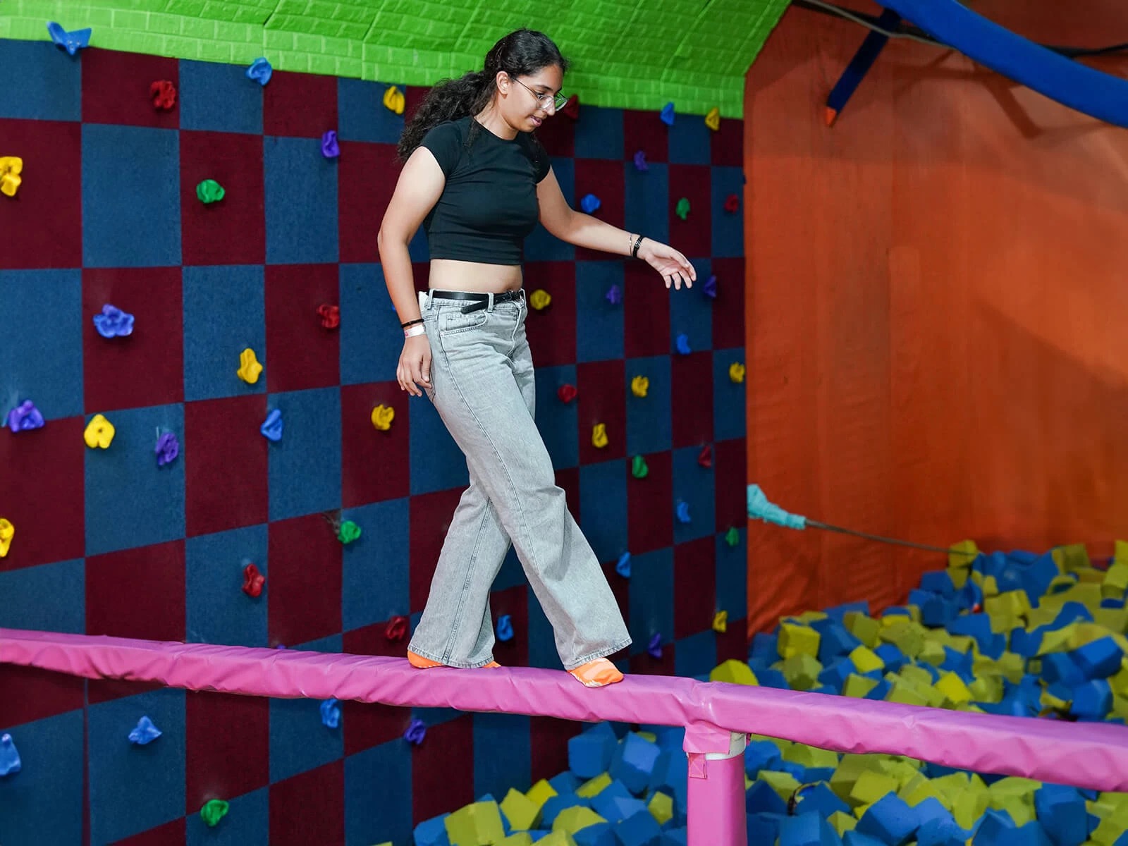 a girl walking on padded log at skyjumper