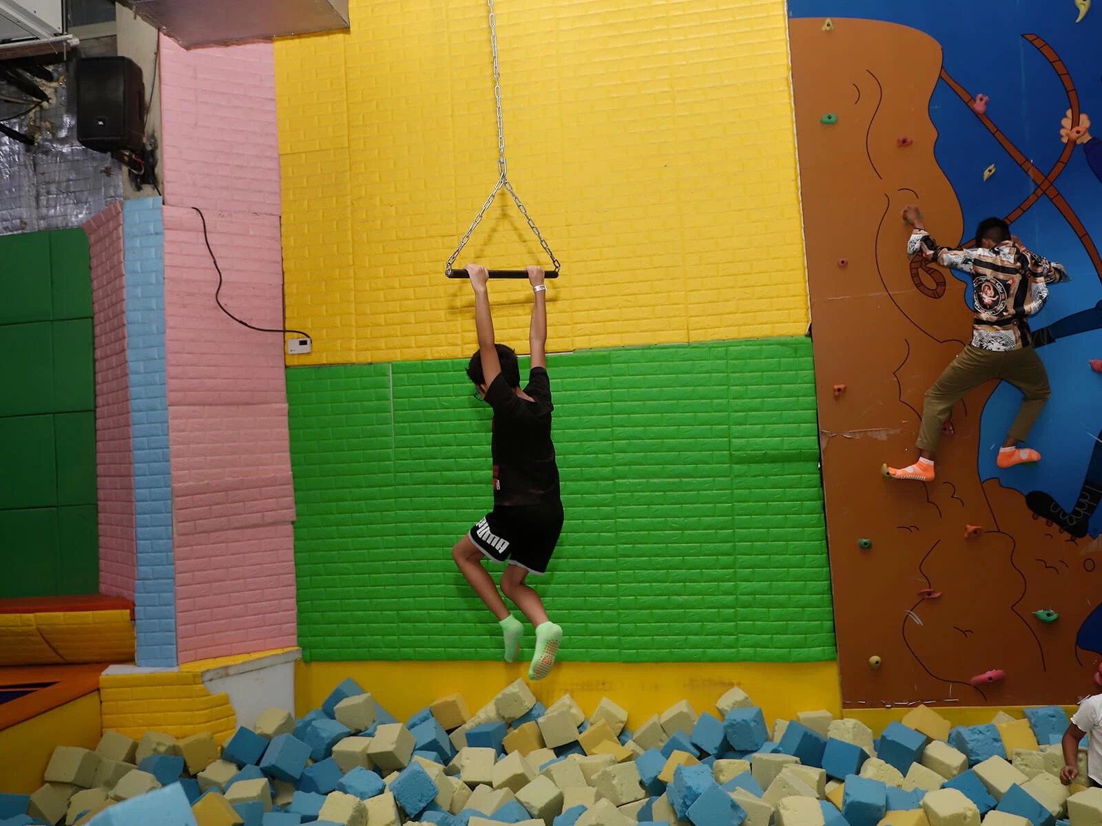 a guy swinging over foam pit at skyjumper