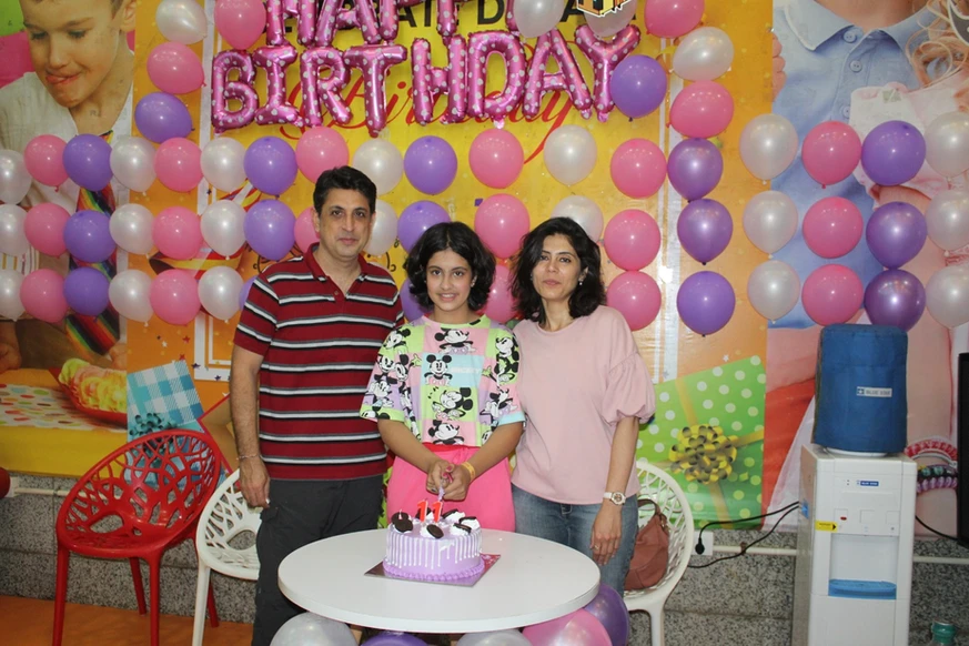 a girl posing for a photo with her parents at skyjumper